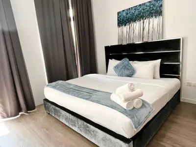 a bedroom with a bed with two towels on it at ModernLux - Lovely Studio Apartment in JVT next to Park in Dubai