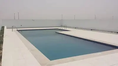 a swimming pool with blue water in a building at ModernLux - Lovely Studio Apartment in JVT next to Park in Dubai