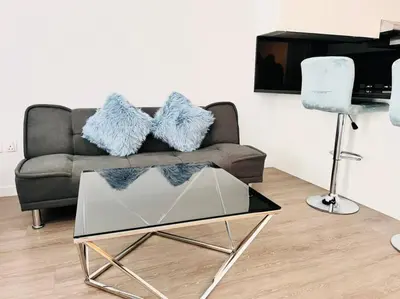 a living room with a couch and a glass table at ModernLux - Lovely Studio Apartment in JVT next to Park in Dubai