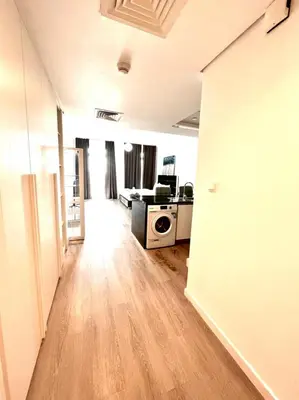 an empty living room with a kitchen and a microwave at ModernLux - Lovely Studio Apartment in JVT next to Park in Dubai