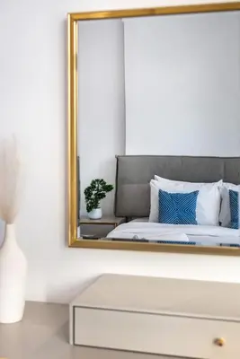 a mirror on a wall above a bed in a room at The Lofts - Luxurious space with Burj Khalifa View in Dubai