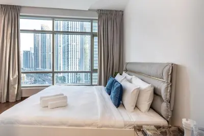 a bedroom with a large bed with a large window at The Lofts - Luxurious space with Burj Khalifa View in Dubai