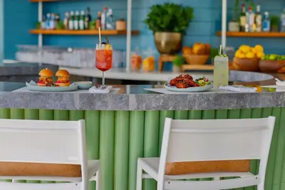 two chairs sitting at a counter with plates of food at Marriott Resort Palm Jumeirah, Dubai in Dubai