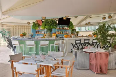 a restaurant with tables and chairs and a bar at Marriott Resort Palm Jumeirah, Dubai in Dubai