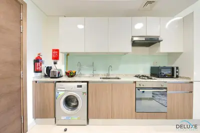 a kitchen with a washer and a washing machine at Perfect Studio Getaway Next to the Iconic Creek Harbour, Azizi Aliyah, Al Jaddaf, by Deluxe Holiday Homes in Dubai