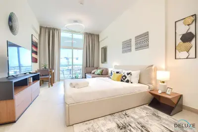 a bedroom with a large bed and a living room at Perfect Studio Getaway Next to the Iconic Creek Harbour, Azizi Aliyah, Al Jaddaf, by Deluxe Holiday Homes in Dubai