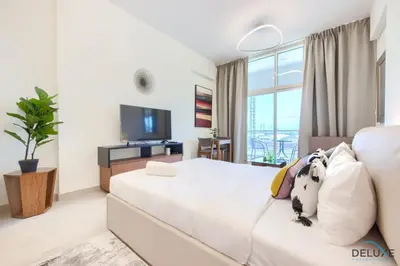 a bedroom with a white bed with a dog on it at Perfect Studio Getaway Next to the Iconic Creek Harbour, Azizi Aliyah, Al Jaddaf, by Deluxe Holiday Homes in Dubai