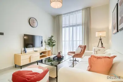 a living room with a couch and a tv at Homely 1BR at Binghatti Avenue Al Jaddaf by Deluxe Holiday Homes in Dubai