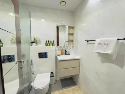 a bathroom with a shower and a toilet and a sink at LV13 - Elegant Studio in Lake View Tower in Dubai
