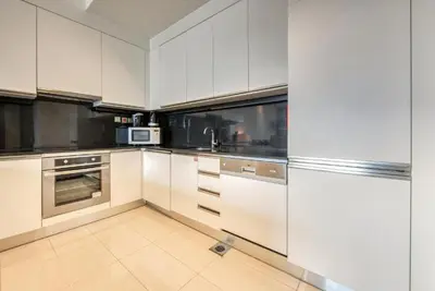 a kitchen with white cabinets and stainless steel appliances at Graceful 1BR at The Address Residences Dubai Marina by Deluxe Holiday Homes in Dubai