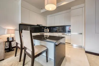 a kitchen with white cabinets and a island with chairs at Graceful 1BR at The Address Residences Dubai Marina by Deluxe Holiday Homes in Dubai