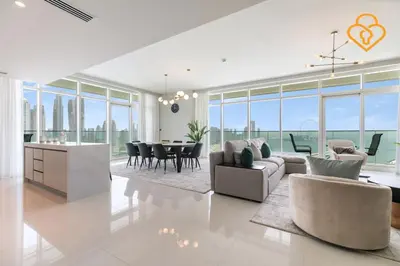 a living room with a couch and a table with chairs at Fascinating Views! Large 4BR Private Beach Access, Emaar BeachFront in Dubai