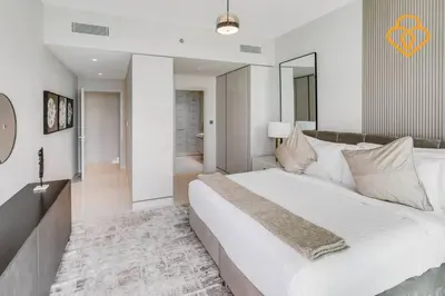 a bedroom with a large white bed and a bathroom at Fascinating Views! Large 4BR Private Beach Access, Emaar BeachFront in Dubai