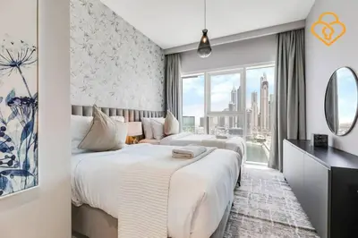 two beds in a hotel room with a window at Fascinating Views! Large 4BR Private Beach Access, Emaar BeachFront in Dubai