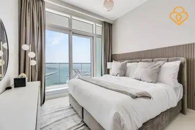 a bedroom with a large bed and a large window at Fascinating Views! Large 4BR Private Beach Access, Emaar BeachFront in Dubai