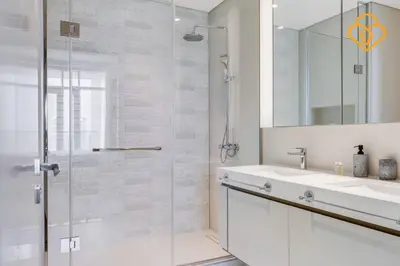 a bathroom with a glass shower and a sink at Fascinating Views! Large 4BR Private Beach Access, Emaar BeachFront in Dubai