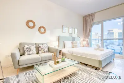 a living room with a couch and a table at Pleasant Studio at Safir Tower 1 Business Bay by Deluxe Holiday Homes in Dubai