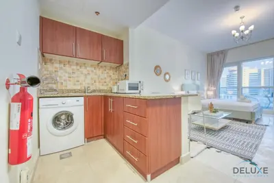 a kitchen with a washer and dryer at Pleasant Studio at Safir Tower 1 Business Bay by Deluxe Holiday Homes in Dubai