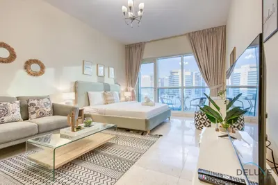 a living room with a couch and a bed at Pleasant Studio at Safir Tower 1 Business Bay by Deluxe Holiday Homes in Dubai