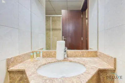 a bathroom with a sink with a large mirror at Pleasant Studio at Safir Tower 1 Business Bay by Deluxe Holiday Homes in Dubai