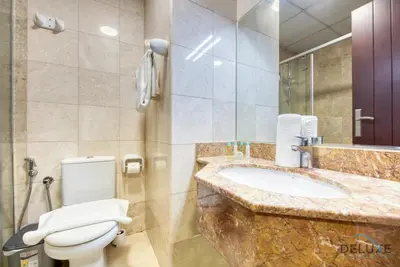 a bathroom with a white toilet and a sink at Pleasant Studio at Safir Tower 1 Business Bay by Deluxe Holiday Homes in Dubai