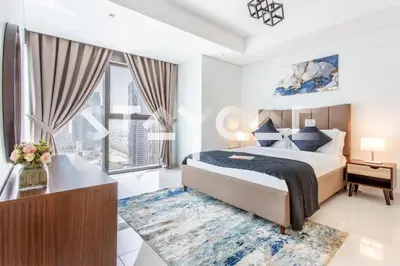 a bedroom with a bed and a desk and a window at Staycae Holiday Homes - Paramount Midtown in Dubai