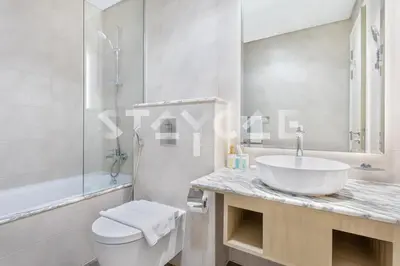 a white bathroom with a sink and a toilet at Staycae Holiday Homes - Paramount Midtown in Dubai