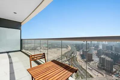 a balcony with a wooden bench and a view of a city at ALiving Elegant 1BR I Burj Khalifa View I Paramount Towers- 6103 in Dubai