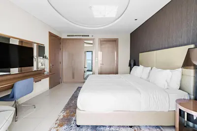 a hotel room with a large bed and a television at ALiving Elegant 1BR I Burj Khalifa View I Paramount Towers- 6103 in Dubai