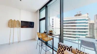 an apartment with a balcony with a table and chairs at Stylish Studio with Burj Khalifa View in Dubai