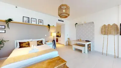 a bedroom with a large bed and a desk at Stylish Studio with Burj Khalifa View in Dubai