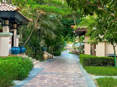 a brick walkway next to a house with trees at Fabulous 1 bedroom apartment at 5 Star Resort in Dubai