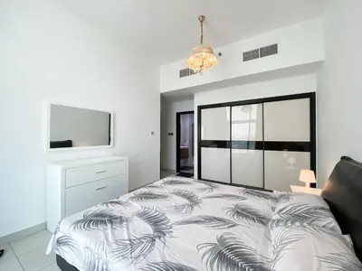 a bedroom with a bed and a flat screen tv at DUBAI - Glitz 3 Residences - MAJESTIC Luxe Holiday Home - 2BR - Sleep 4 - FOR FAMILIES & COUPLES STAYS ONLY in Dubai