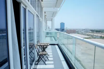 a balcony in a building with two chairs on it at DUBAI - Glitz 3 Residences - MAJESTIC Luxe Holiday Home - 2BR - Sleep 4 - FOR FAMILIES & COUPLES STAYS ONLY in Dubai