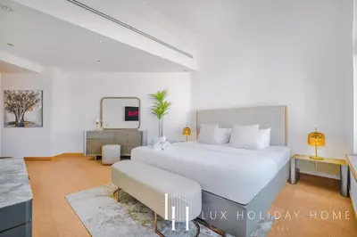 a bedroom with a large white bed and a couch at LUX - The Shoreline Penthouse Suite in Dubai