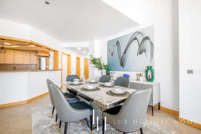 a dining room with a table and chairs at LUX - The Shoreline Penthouse Suite in Dubai