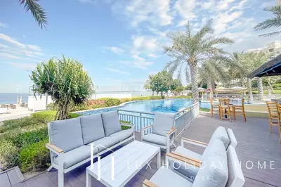 a patio with chairs and a swimming pool at LUX - The Shoreline Penthouse Suite in Dubai