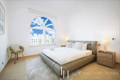 a bedroom with a bed and a window at LUX - The Shoreline Penthouse Suite in Dubai