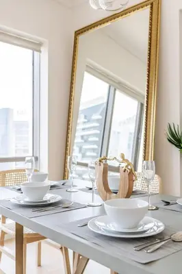 a dining room table with a mirror and glasses at GuestReady - Upscale Modern Apt in Downtown in Dubai