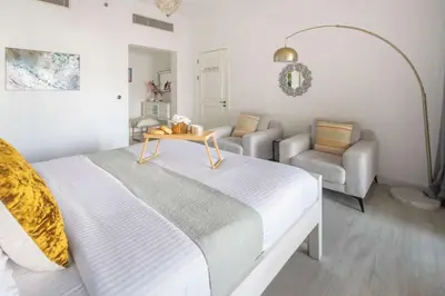 a bedroom with a bed and a table and chairs at Frank Porter - Fairmont Residence South in Dubai