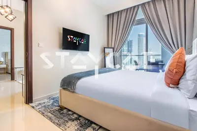 a bedroom with a large bed with a large window at Staycae Holiday Homes - Vera by DAMAC Near Downtown, Business Bay in Dubai