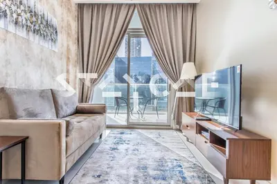 a living room with a couch and a tv at Staycae Holiday Homes - Vera by DAMAC Near Downtown, Business Bay in Dubai