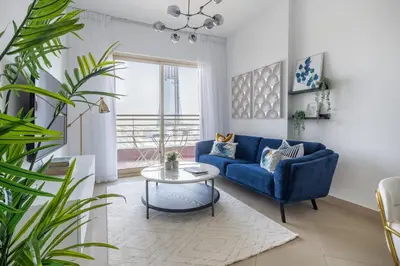 a living room with a blue couch and a table at Frank Porter - Icon Tower 1 in Dubai