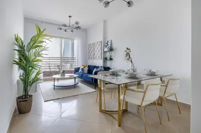a living room with a table and a blue couch at Frank Porter - Icon Tower 1 in Dubai