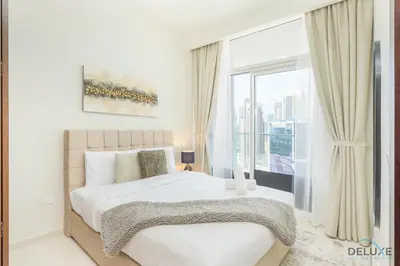 a bedroom with a bed and a large window at Distinguished 1BR at Vera Tower Business Bay by Deluxe Holiday Homes in Dubai