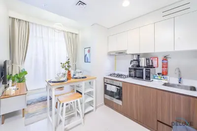 a kitchen with white cabinets and a counter top at Distinguished 1BR at Vera Tower Business Bay by Deluxe Holiday Homes in Dubai