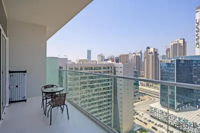 a balcony with two chairs and a table on a building at Distinguished 1BR at Vera Tower Business Bay by Deluxe Holiday Homes in Dubai
