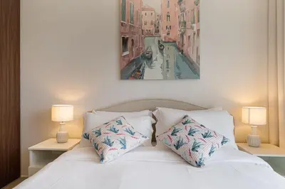 a bedroom with a white bed with two lamps at Alluring 1 BD Apartment in Business Bay with Burj Khalifa view in Dubai