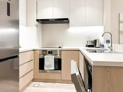 a kitchen with white cabinets and an oven at Relaxing 1 bedroom apartment at 5 Star Resort in Dubai