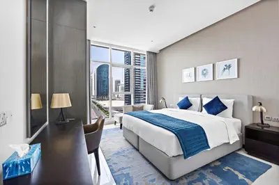 a bedroom with a large bed and a large window at ALiving Modern 1BR Apartment with Balcony & Canal View I DAMAC Maison Prive A- 517 in Dubai